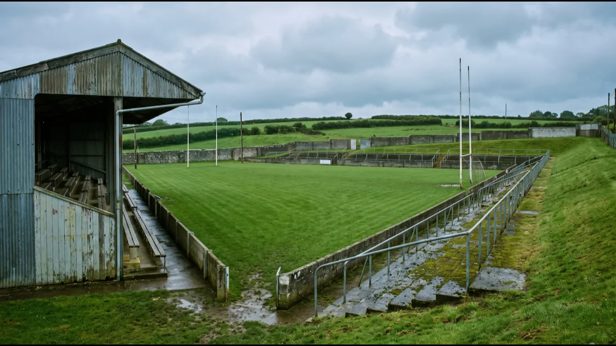 A large county sports ground with a single covered stand and open grass banking on the far side, under soft grey Irish light