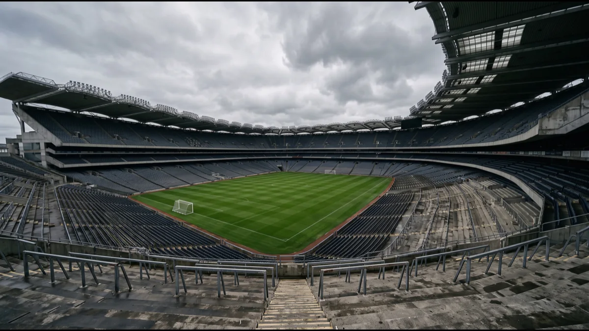 A large stadium bowl with a single open standing terrace at one end, seen from the upper tier under a soft grey Irish sky