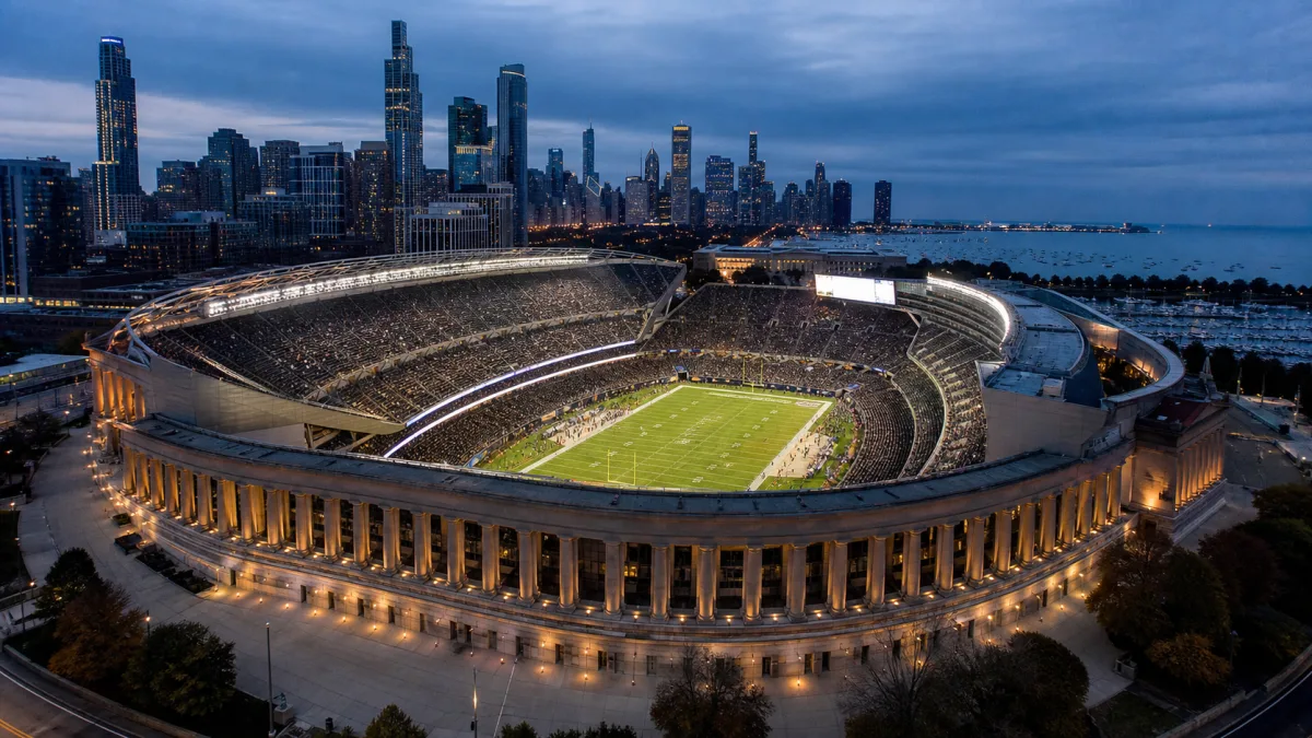 Historic Chicago lakefront stadium with classical colonnades surrounding a modern football bowl at dusk